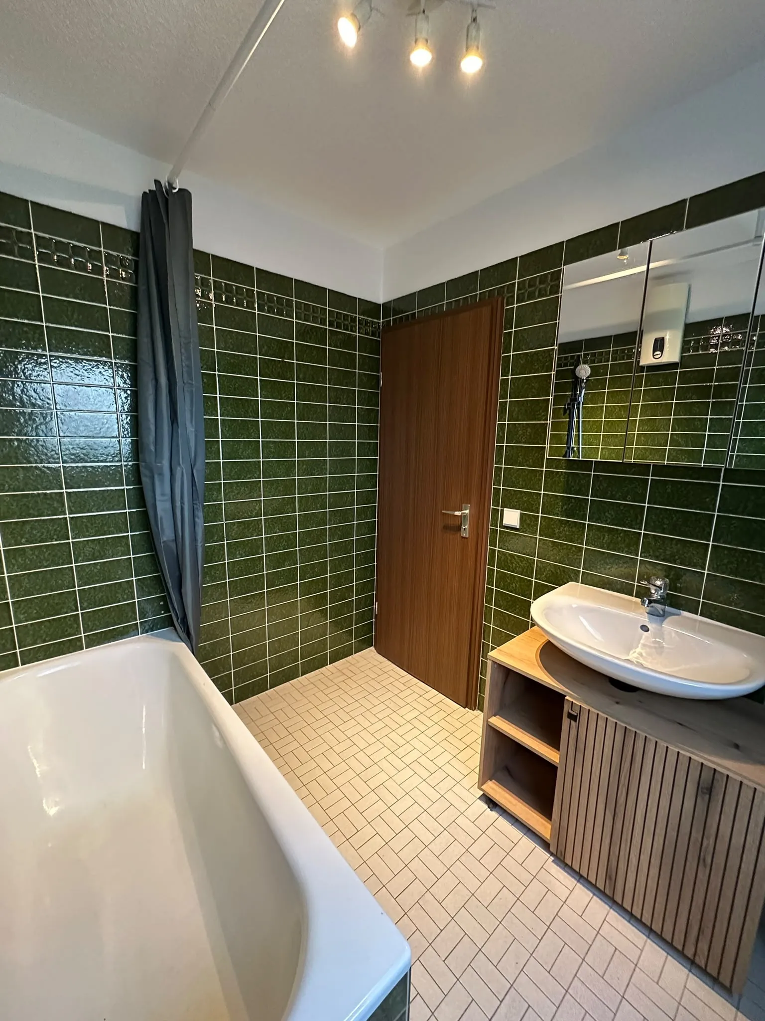 Waschtisch mit Holzunterschrank und Badewanne im Gemeinschaftsbad