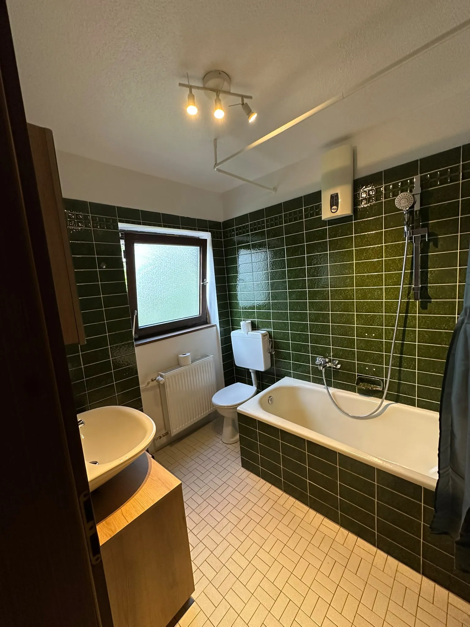 Badewanne mit Dusche, Toilette und Fenster im Gemeinschaftsbad