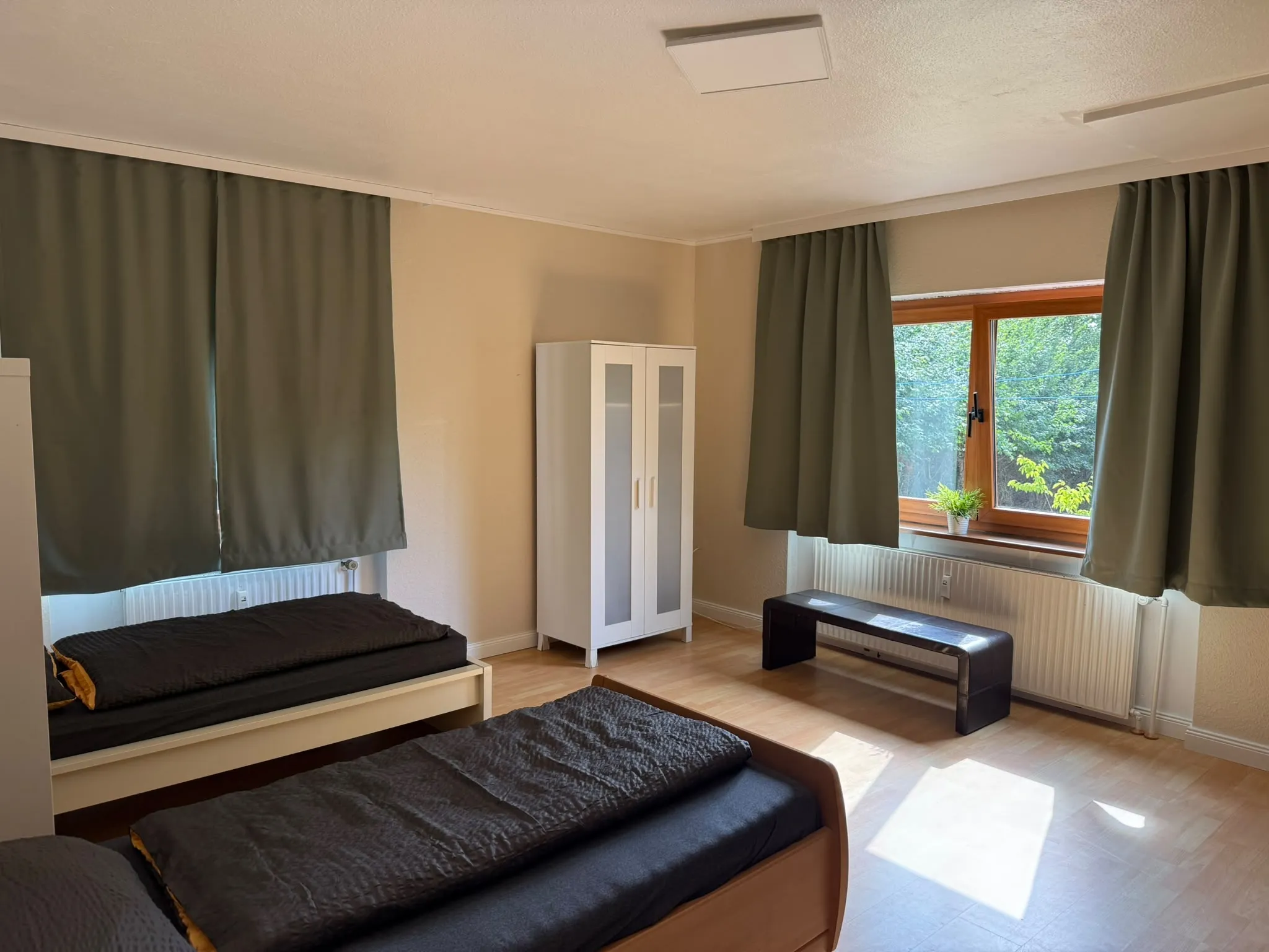 Helles Zimmer mit zwei Einzelbetten und Kleiderschrank