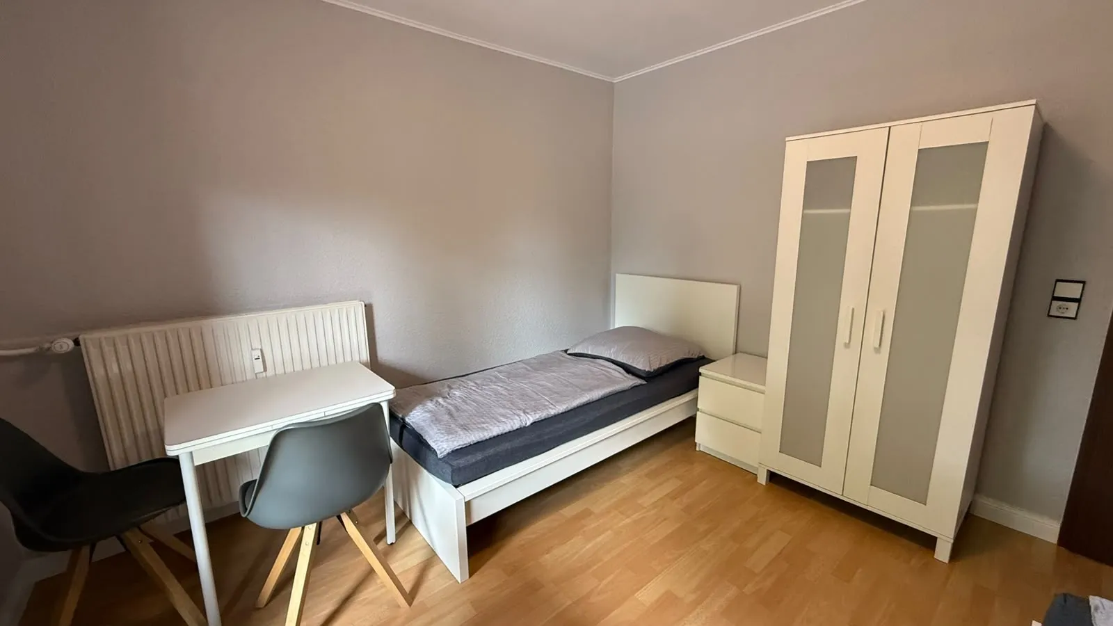 Zimmer mit Einzelbett, Schreibtisch und Schrank