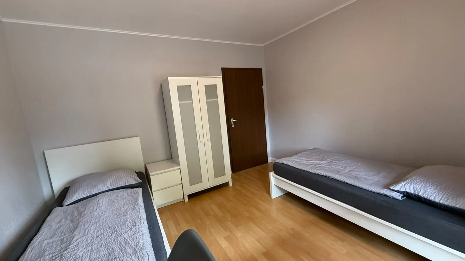 Zwei Einzelbetten mit Bettwäsche in einem Gästezimmer